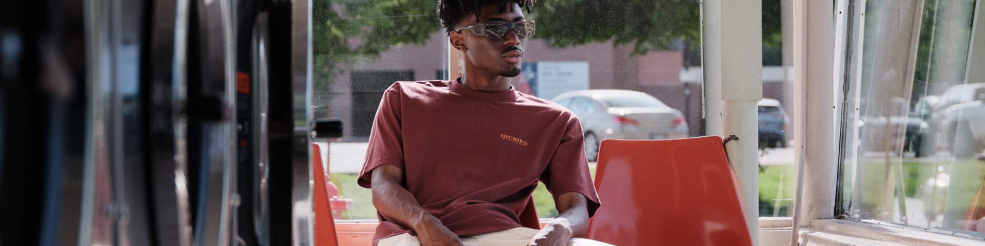 Young man sitting comfortably in a laundromat 